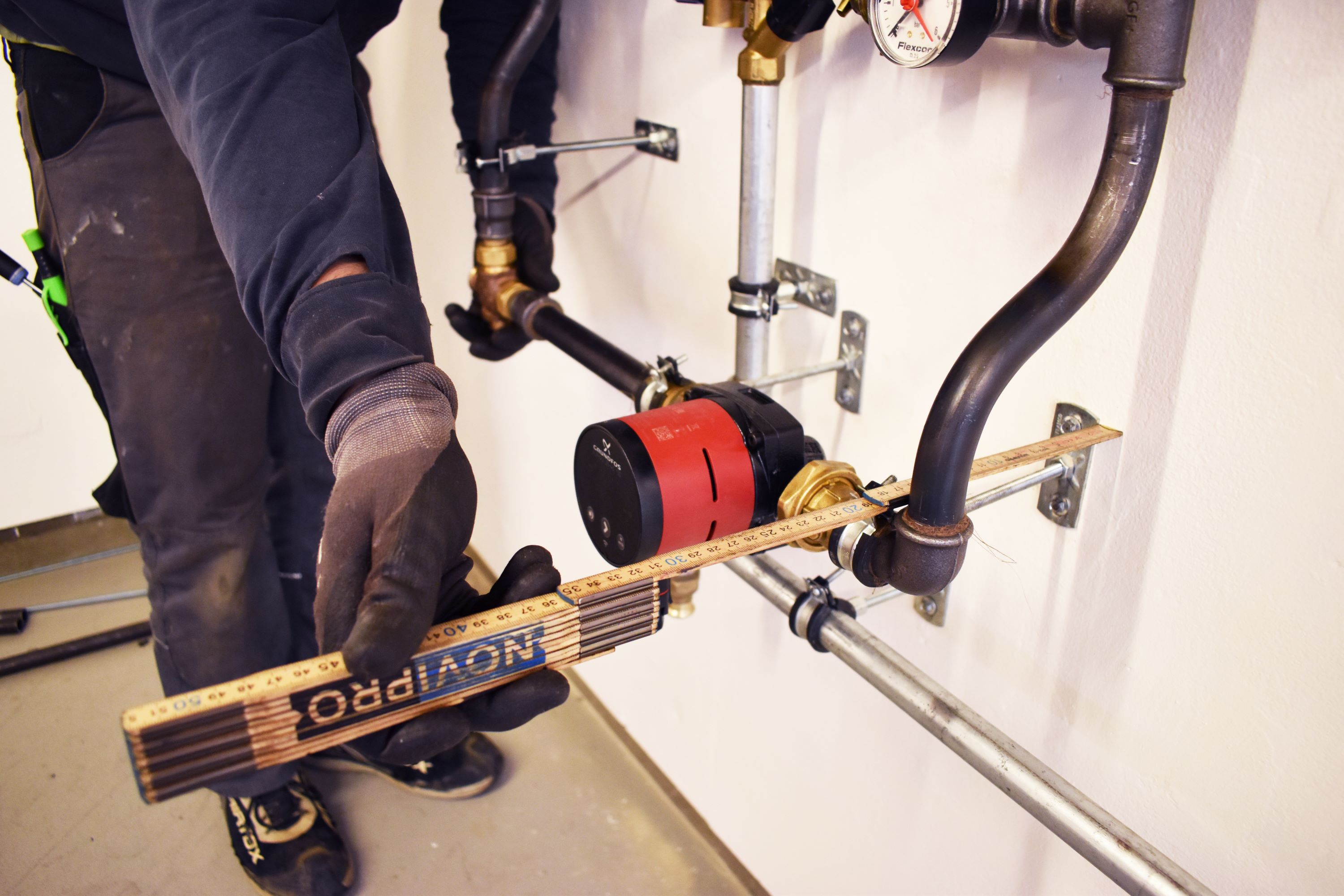 Opmåling med tomstok, det gælder om at være meget præcis, når man som vvs-energispecialist skal opsætte rør til varmeanlæg.