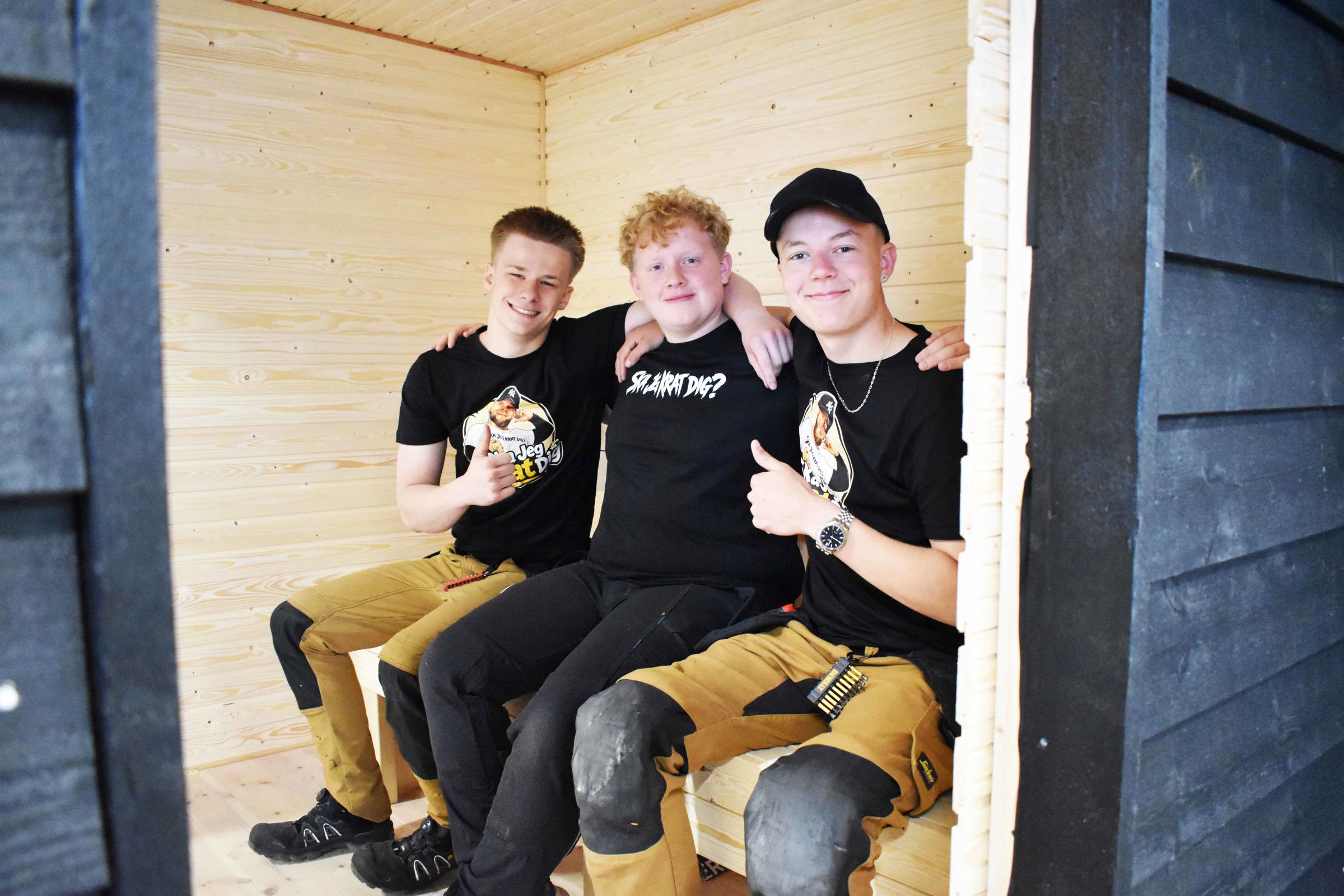 Fra venstre er det Elias, Jonas og Kasper, og de har haft en god tur til Færøerne. Her sidder de i en nybygget sauna i tømrerværkstedet.