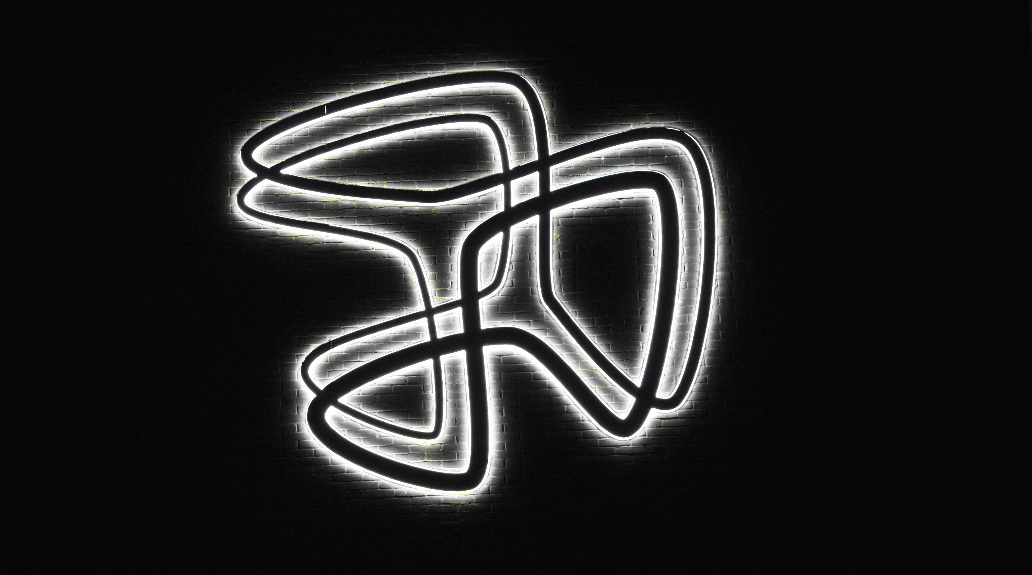 Hansenbergs logo ses oplyst på muren en mørk aften.