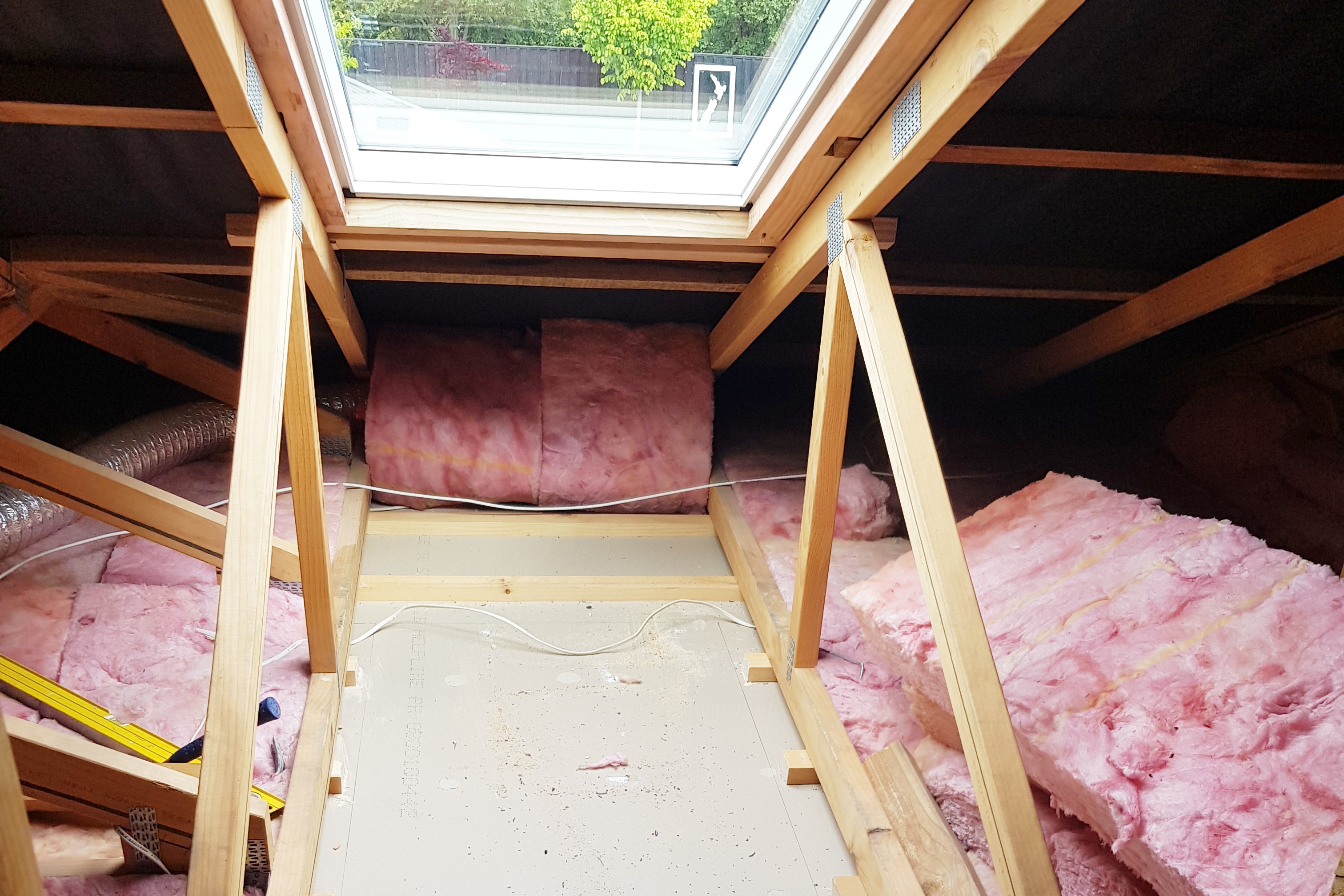 Billedet, som en tømrerlærling på oplæring i udlandet har taget (OPU), viser et loft med lyserød isolering.
