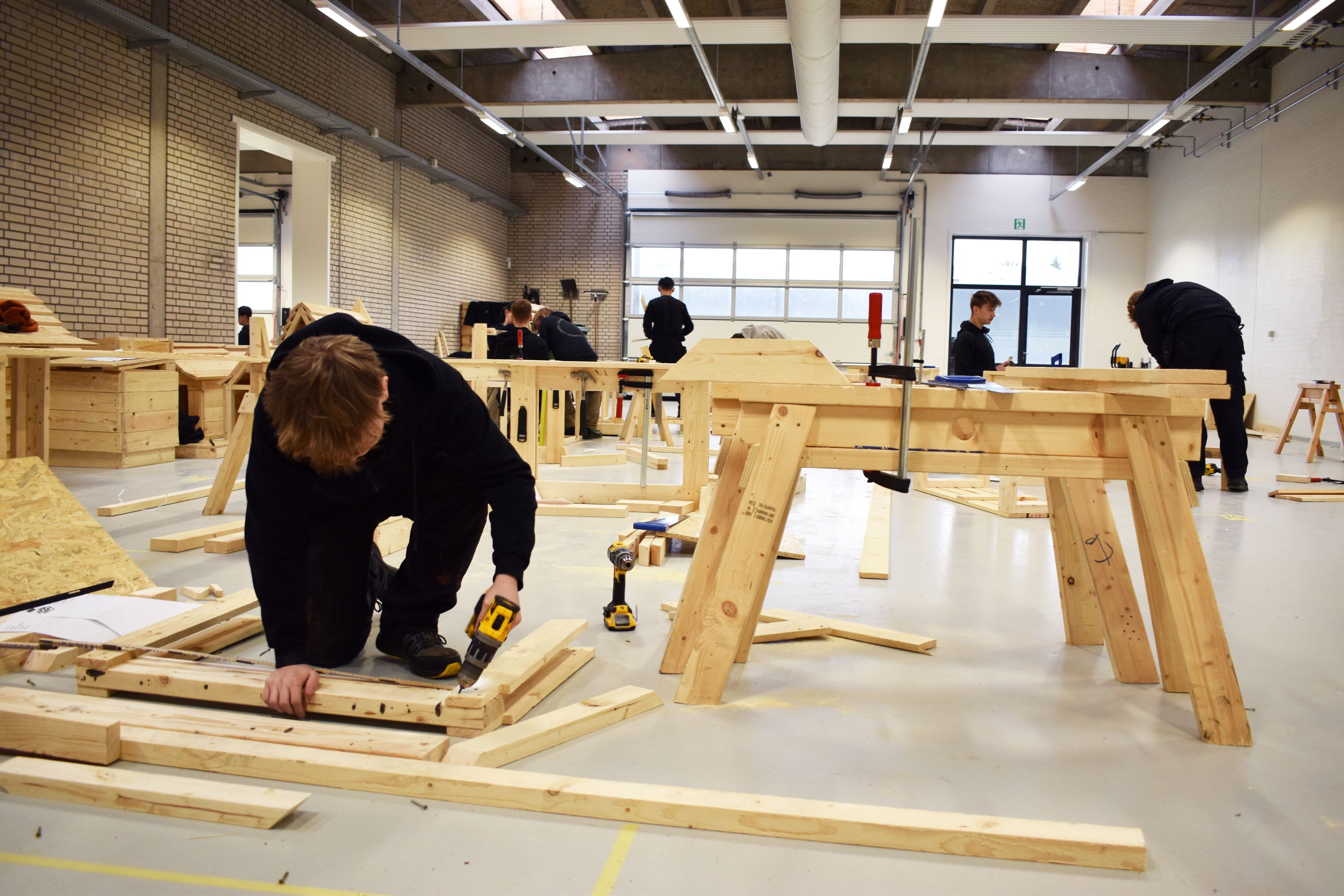 Tømrereleverne arbejder i Hansenbergs tømrerværksted.