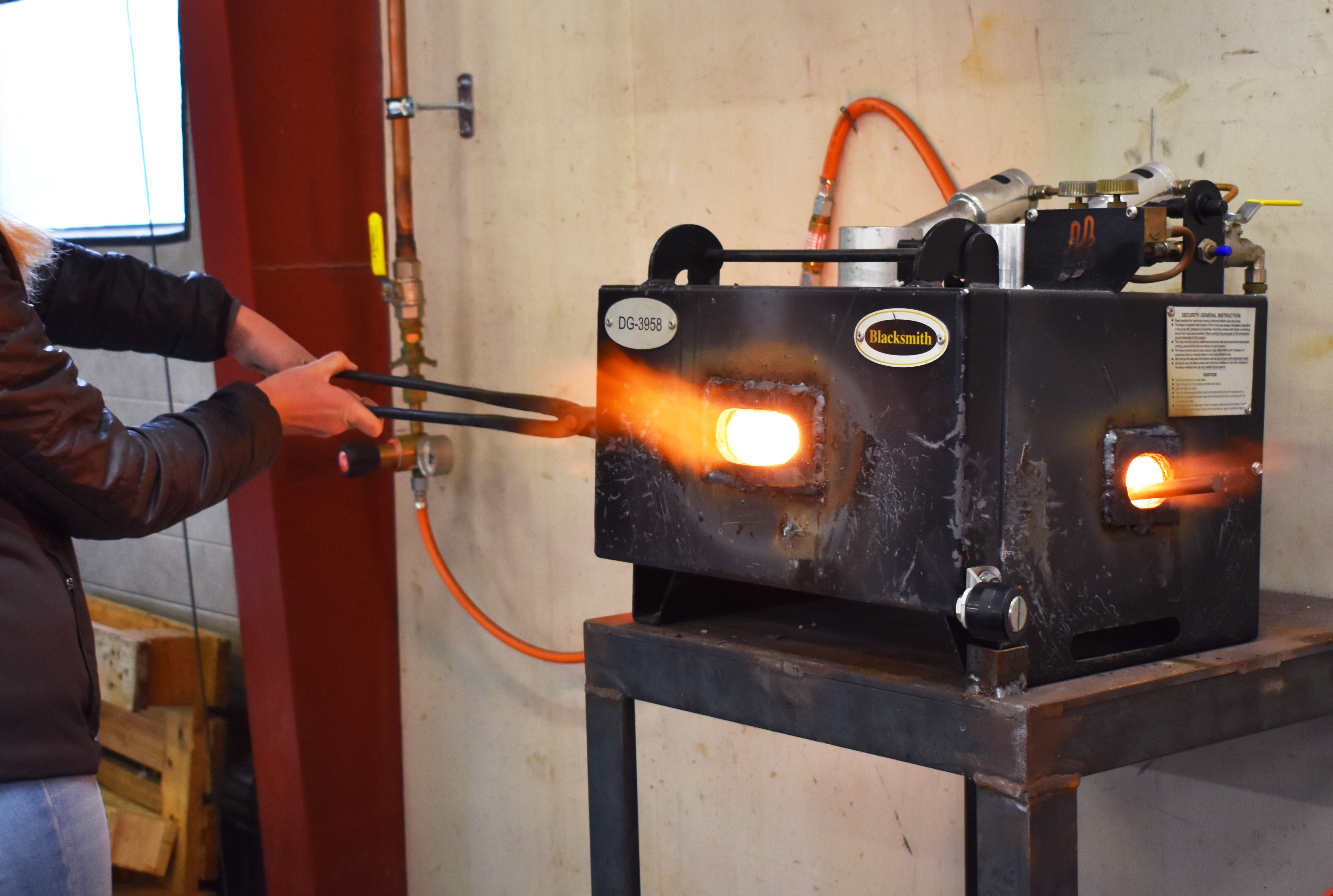 En af deltagerne til Prøv et fag for elever i 4.-10. klasse, er ved at smede hestesko, og lægger hesteskoen til opvarmning i essen.