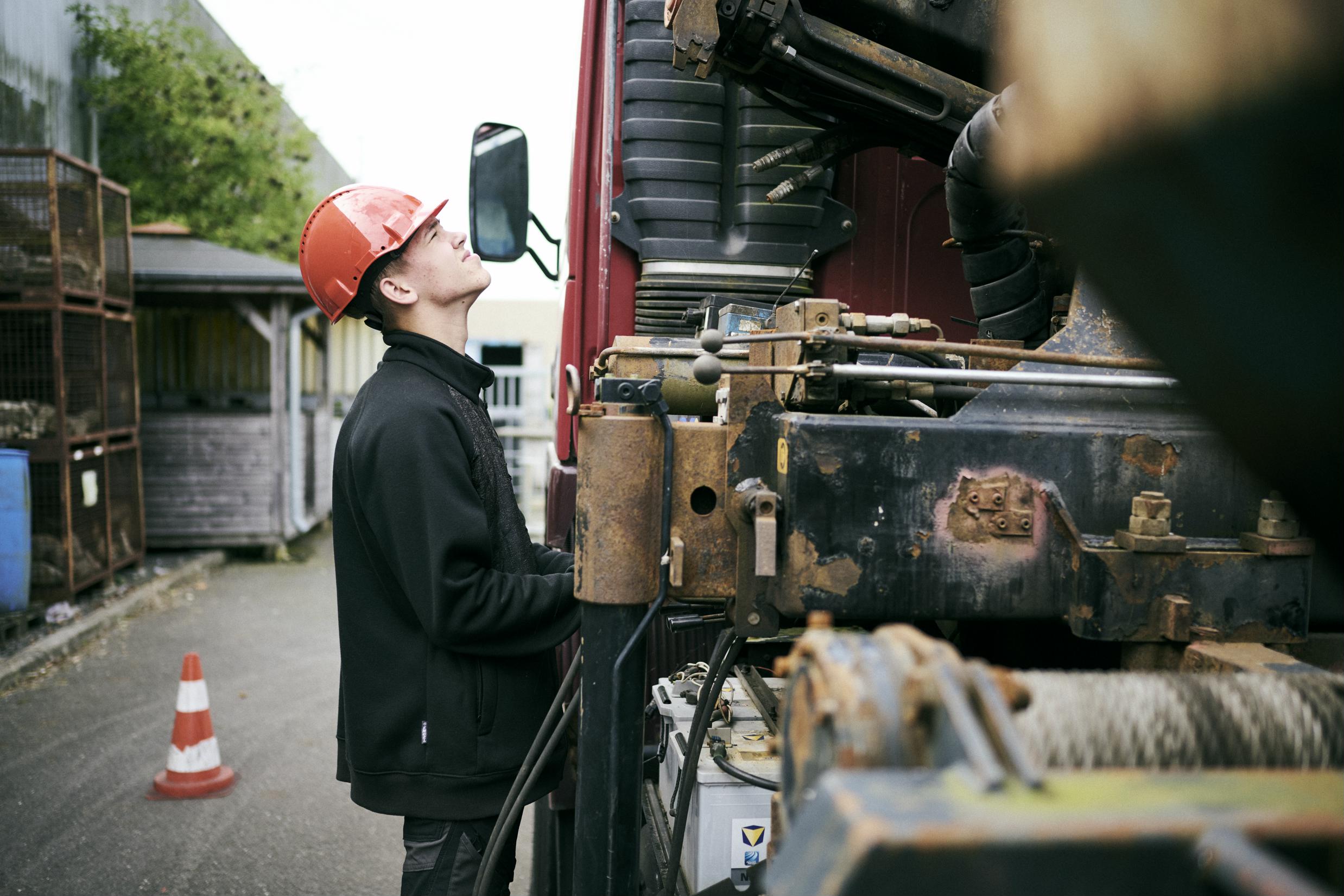 En elev på vejgodstransportuddannelsen styrer kranen på en lastbil.