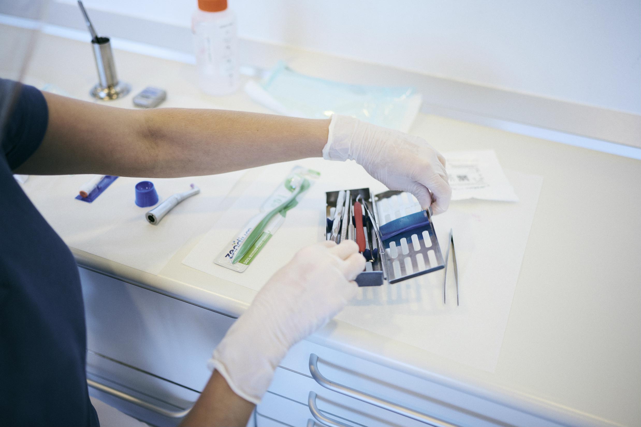 En tandklinikassistentelev finder de sterile instrumenter i skolens tandklinik.