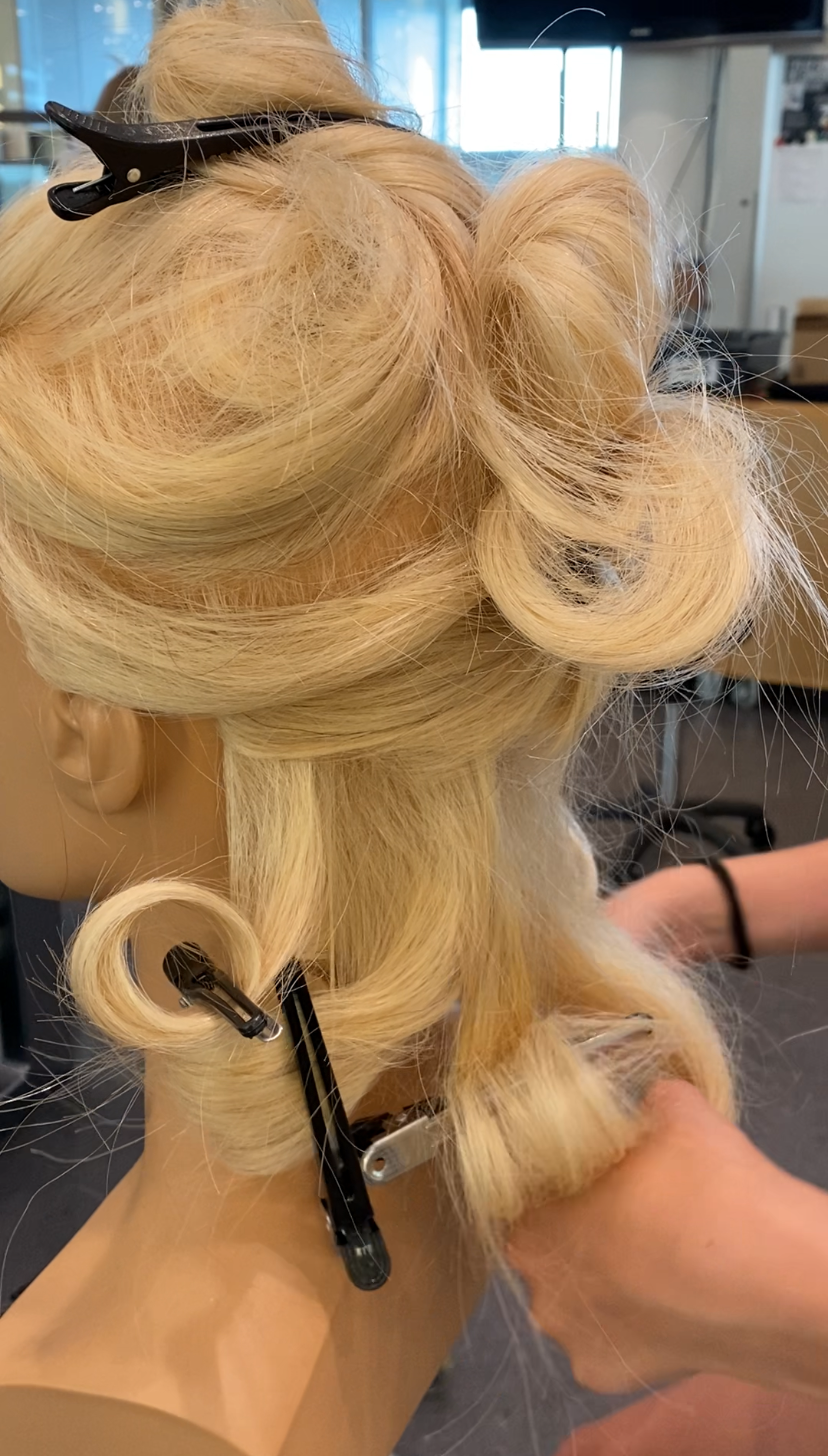 En deltager på BeautyCamp er ved at sætte hår under SommerCamp på Hansenberg.