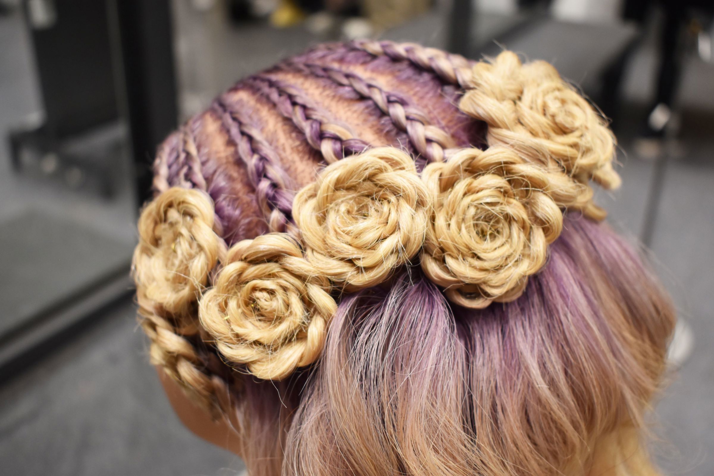 Smuk håropsætning med fletninger snoet som roser skabt af frisørelev til Årets elevteam 2023 på Hansenberg