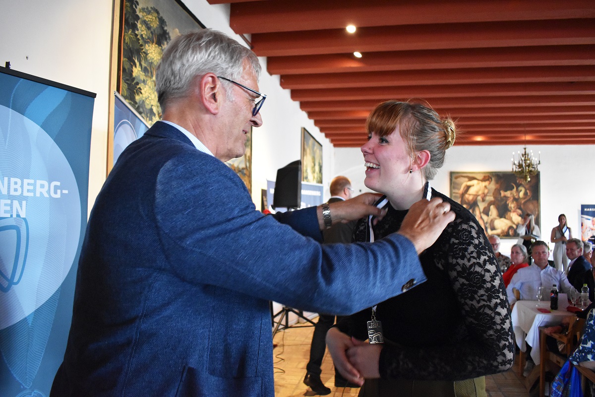 Koldings borgmester overrækker Hansenberg-medaljen til Lena i Riddersalen på Koldinghus. Lena har modtaget medaljen både som udlært kok og som udlært tjener.