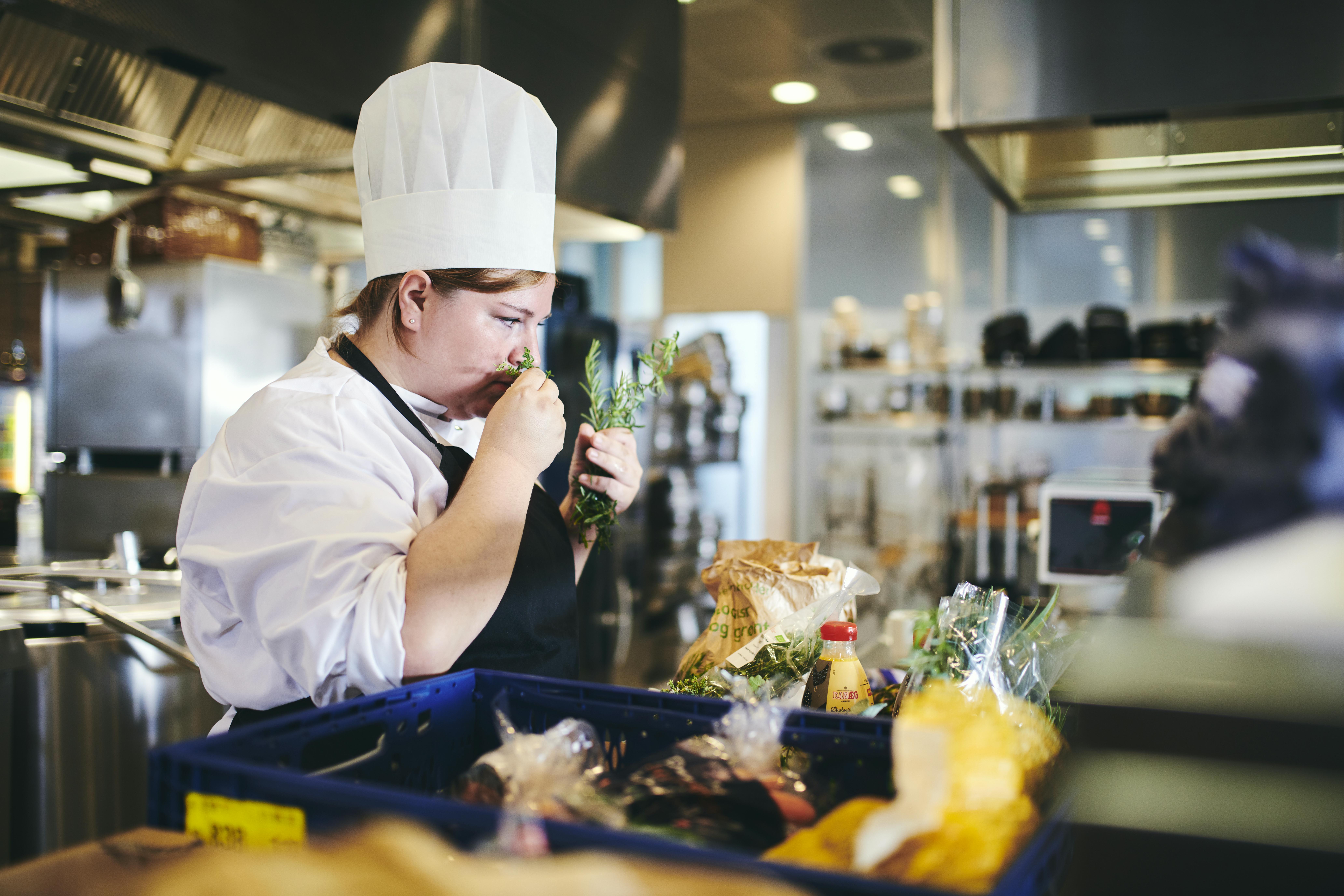 En elev på kokkeuddannelsen tjekker friskheden og duften af råvarerne ved at snuse til dem.