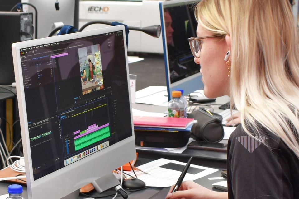 Mediegrafikereleven Cecilie klarede sig rigtig flot under konkurrencerne ved DM i Skills 2024, her arbejder hun i Adobes programmer på en iMac.