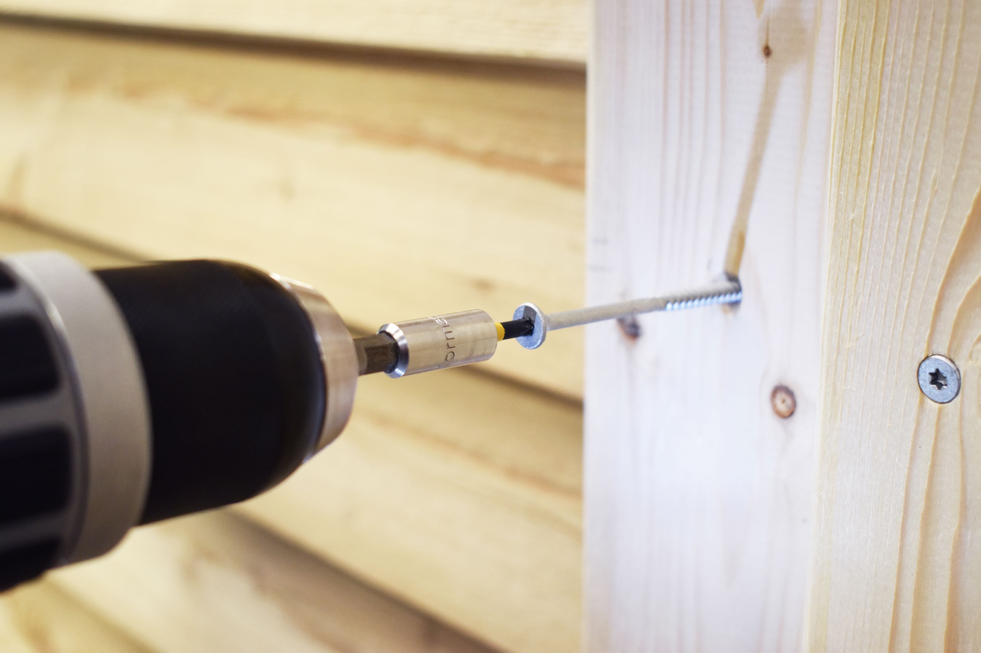 Spidsen af en accumaskine, der skruer en skrue i.