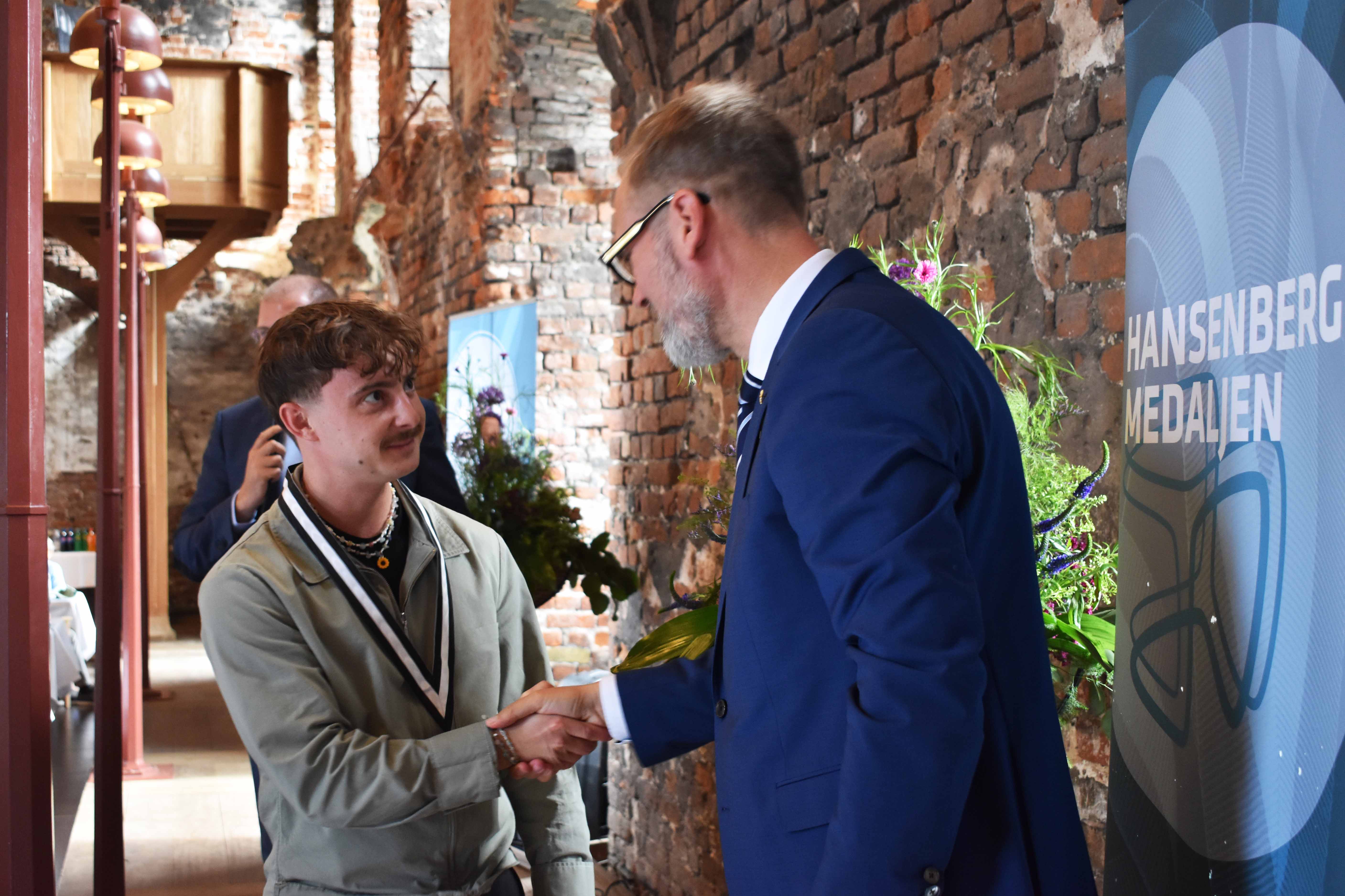 Borgmester i Kolding Kommune Jakob Ville overrækker HANSENBERG-medaljen til kok Alexander Ildskov Nysum.