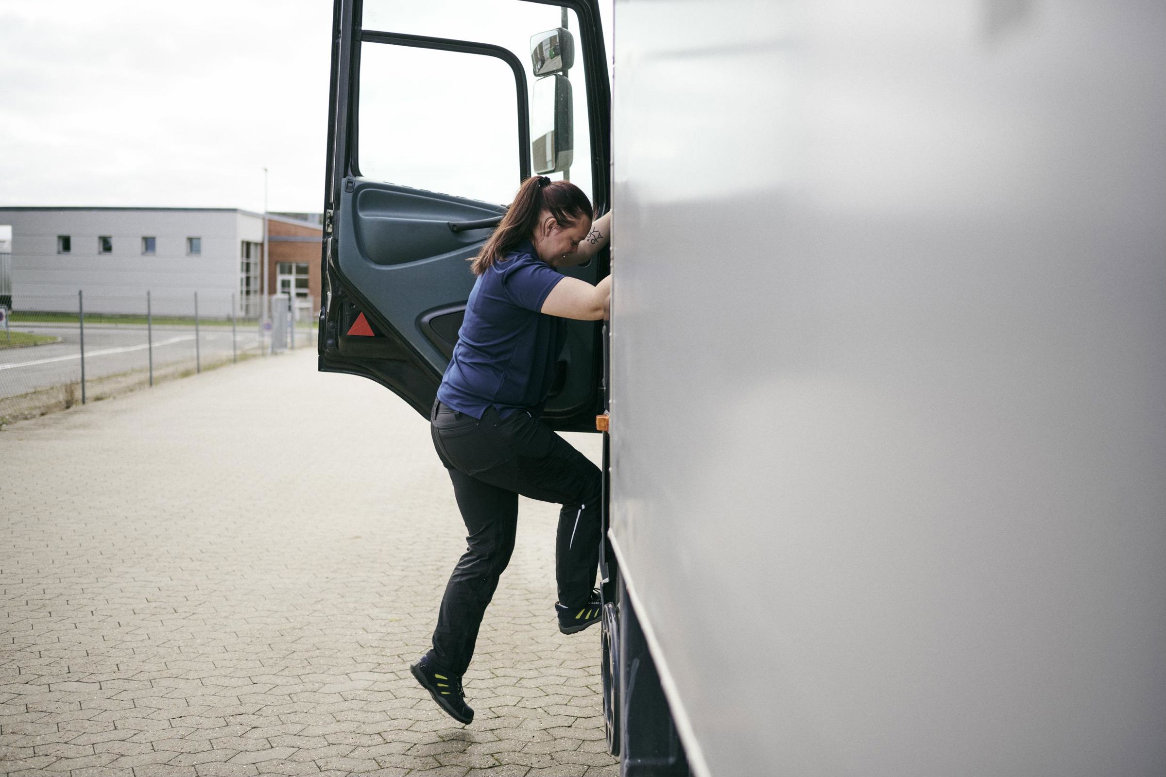 Flere piger vælger at uddanne sig på vejgodstransportuddannelsen, her er en elev på vej op i førerhuset på en lastvogn.