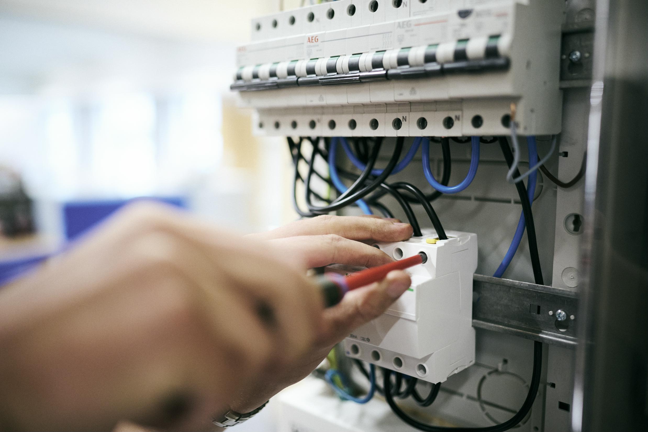 En elektrikerelev er ved at opsætte en en eletavle på skolens værksted.