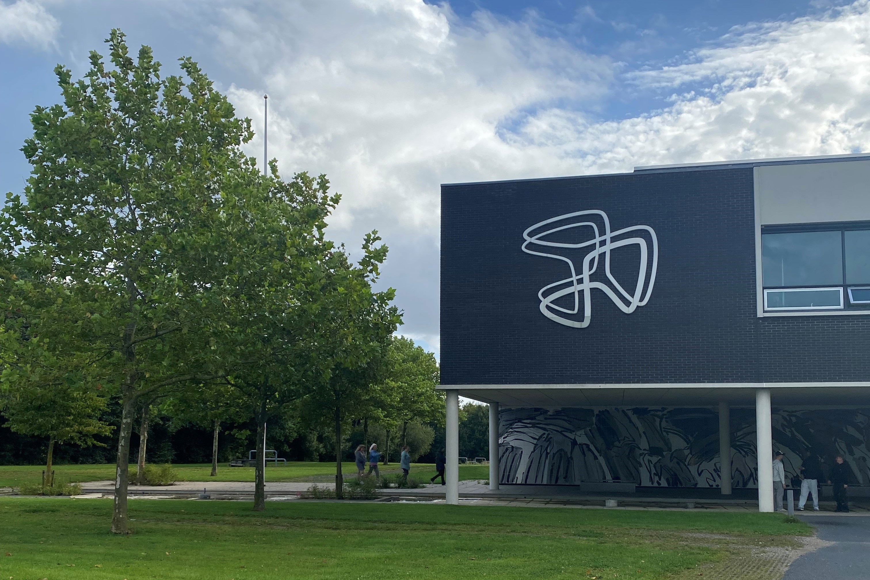 Hovedbygningen med Hansenbergs logo på fronten ved skolens adresse Skovvangen 28 i Kolding.