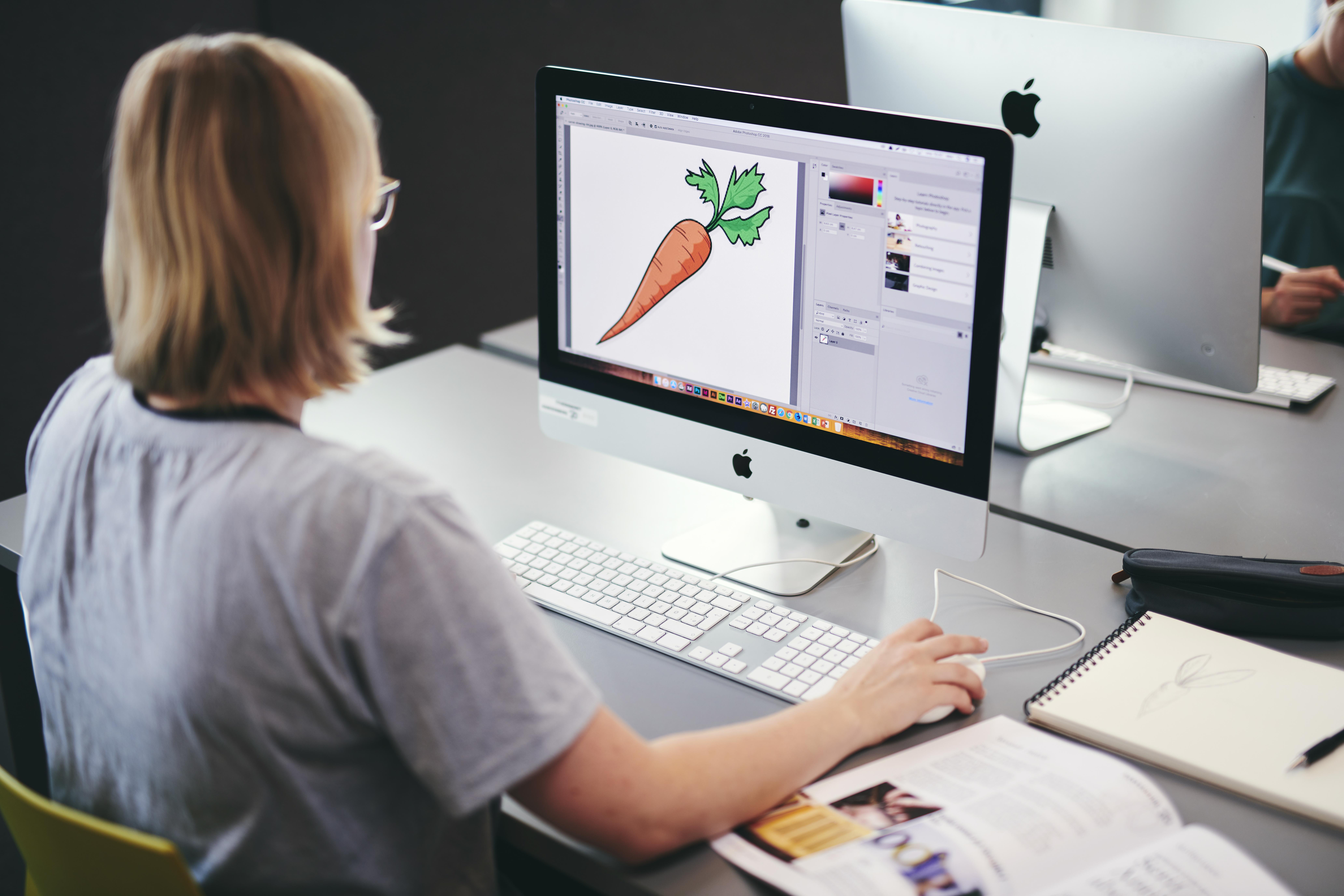 En elev på mediegrafikeruddannelsen på Hansenberg lærer at skabe visuelle udtryk på skolens iMac.