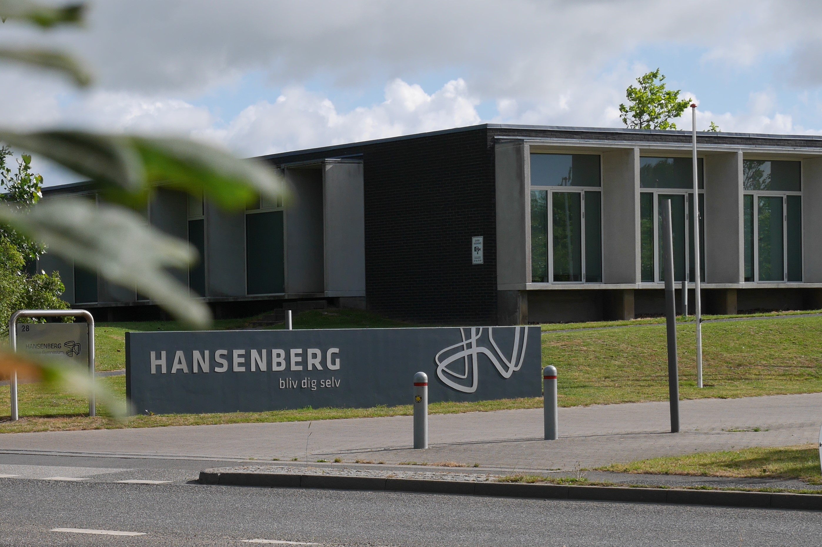 Indkørslen til Skovvangen 28, bag skiltet ses en af bygningerne, der huser Hansenberg Skolehjem (A-, B-, C-, og D-gårdene)