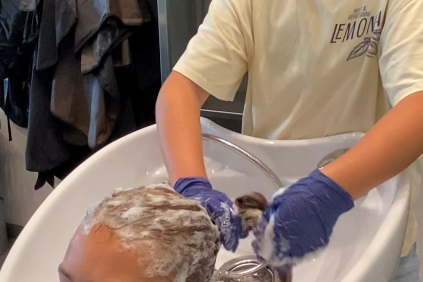 En deltager vasker håret på en af de andre deltagere inden håropsætning på BeautyCamp under SommerCamp på Hansenberg.